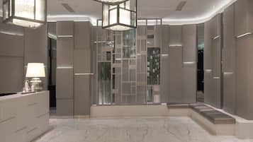 A modern interior with a marble floor, a reception desk, and a decorative partition with integrated lighting.