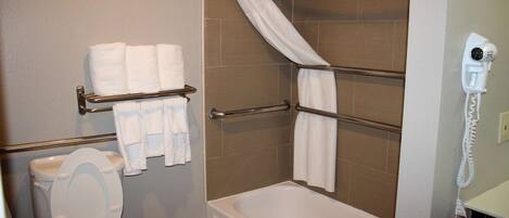 Un baño con inodoro, bañera y zona de ducha.
