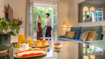 Un comedor con una mesa lista para el desayuno, un sofá y vistas al exterior.