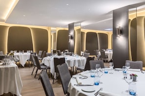 Un restaurant avec des tables rondes, des chaises et un décor intérieur moderne.