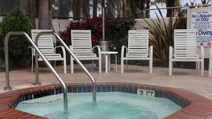 Un jacuzzi con un cartel que indica que no hay socorrista de servicio y está prohibido el clavado.
