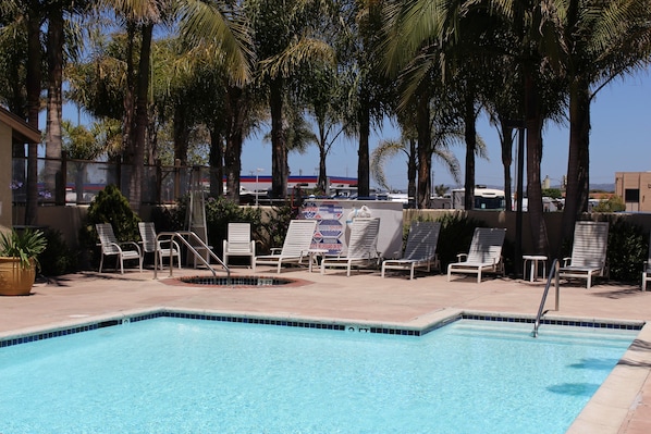 Una piscina al aire libre, sillones reclinables de piscina