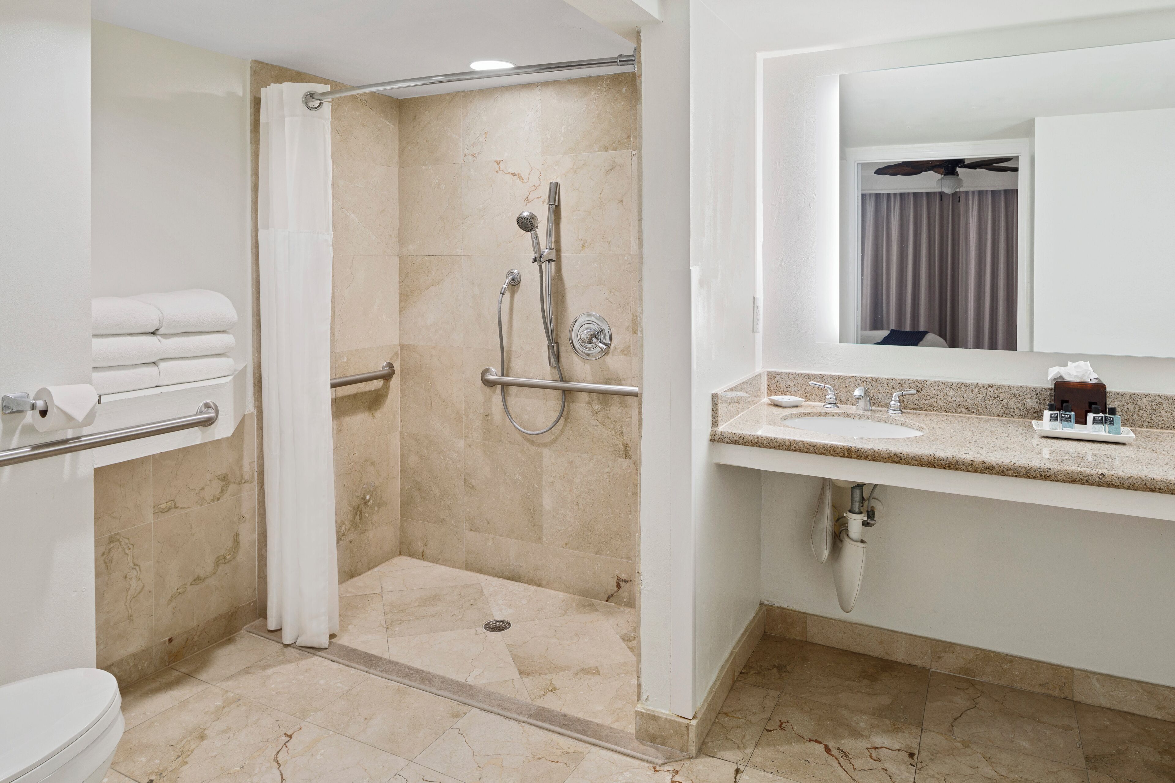 Une salle de bain moderne équipée d’une douche, de toilettes et d’un lavabo.