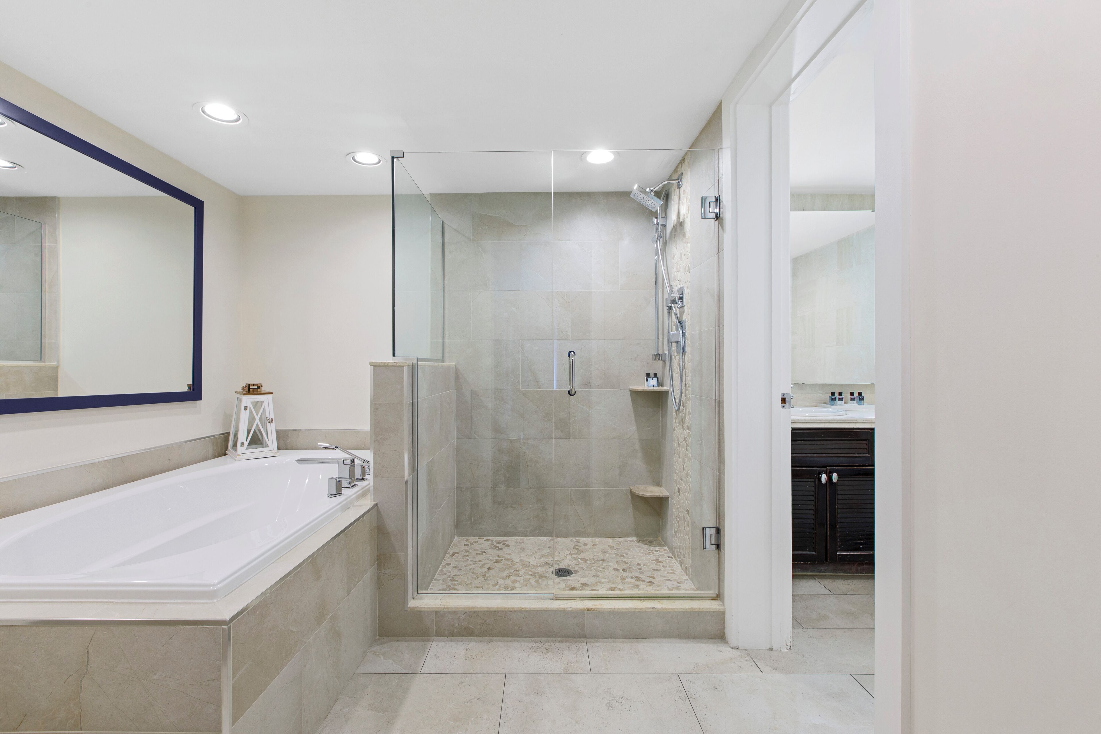 Une salle de bain moderne dotée d’une grande baignoire, d’une douche à parois de verre et d’une douche à l’italienne.