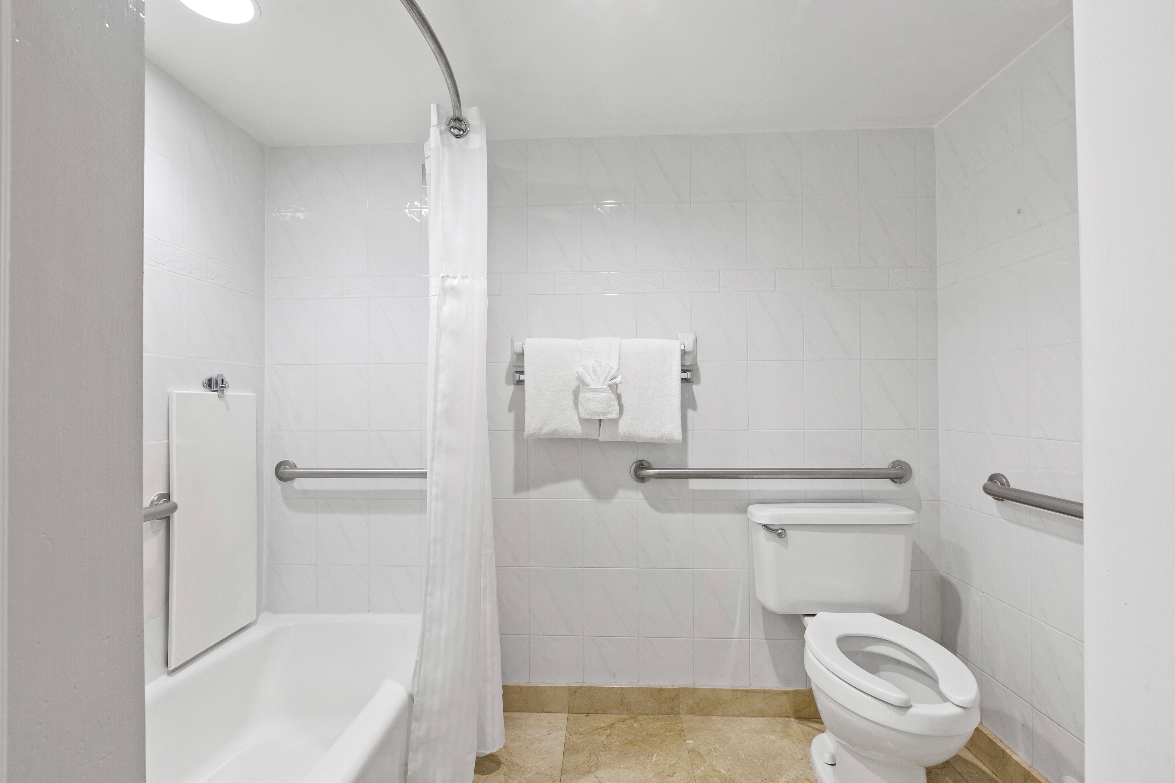 Un baño moderno con bañera, inodoro y cortina de ducha.