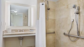 A bathroom with a shower, a sink, and a mirror.
