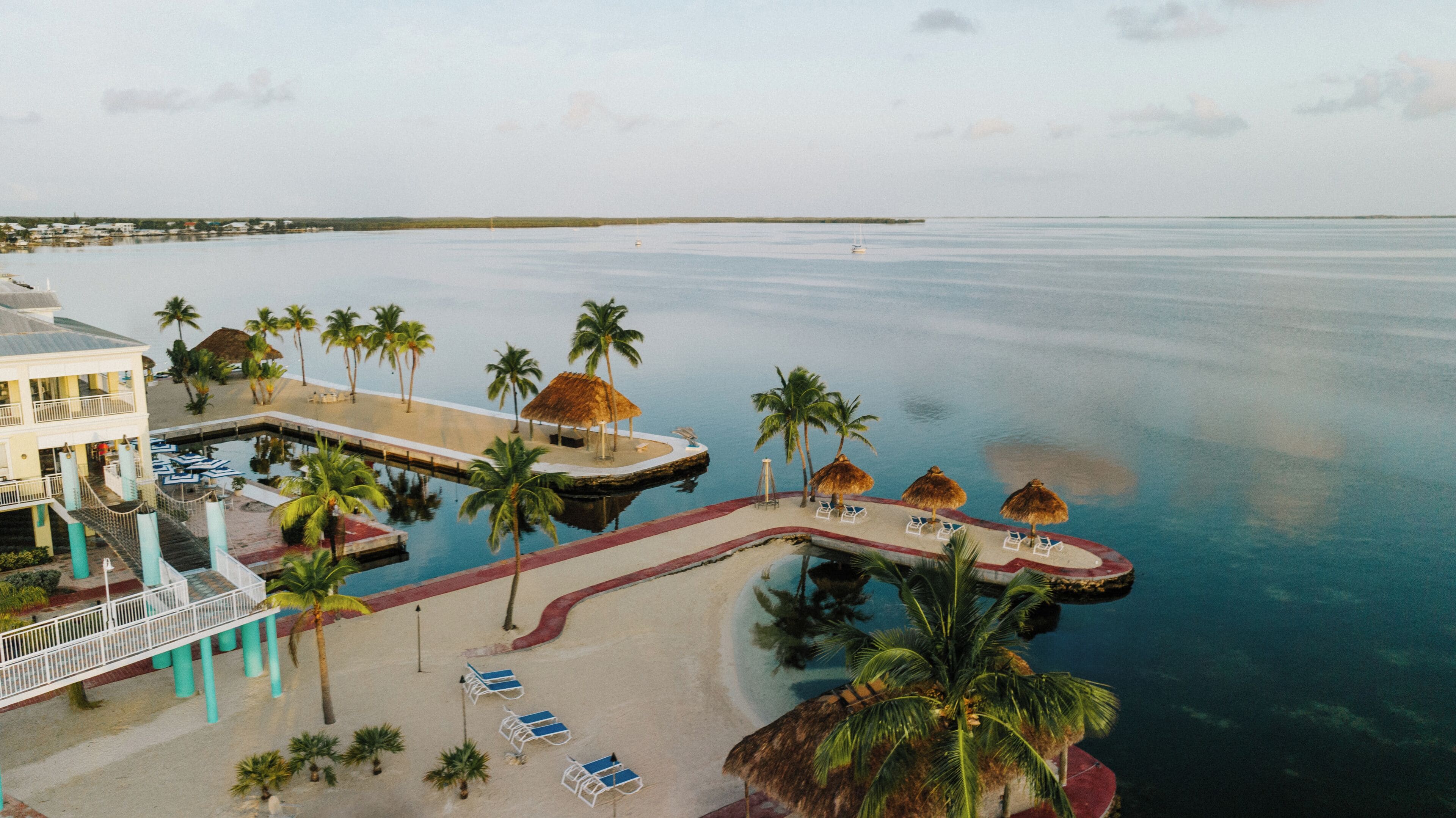 A resort with a pool, palm trees, and a beach area.