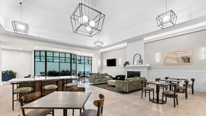 Un espacio habitable amplio con chimenea, muebles modernos y ventanas grandes.