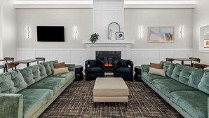Una sala de estar moderna con chimenea, dos sofás y una mesa de centro.