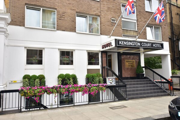 Kensington Court Hotel with a white facade, black-framed windows, and a sign above the entrance. - Kensington Court Hotel (London)