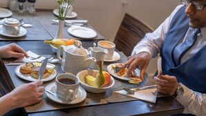 A dining table set with plates, cups, and a pitcher. - Kensington Court Hotel (London)