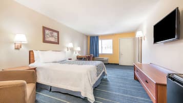 Une chambre d’hôtel équipée d’un lit, d’un bureau, d’une chaise, d’une télévision et d’une armoire.