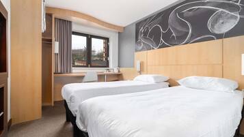 Habitación de hotel con dos camas, un escritorio, una silla, un ventanal y una pared con un dibujo en la pizarra.