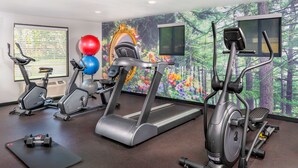 A gym with treadmills, elliptical machines, and a stationary bike. There are exercise balls and dumbbells on the floor. - Best Western Plus Raffles Inn & Suites (Anaheim)
