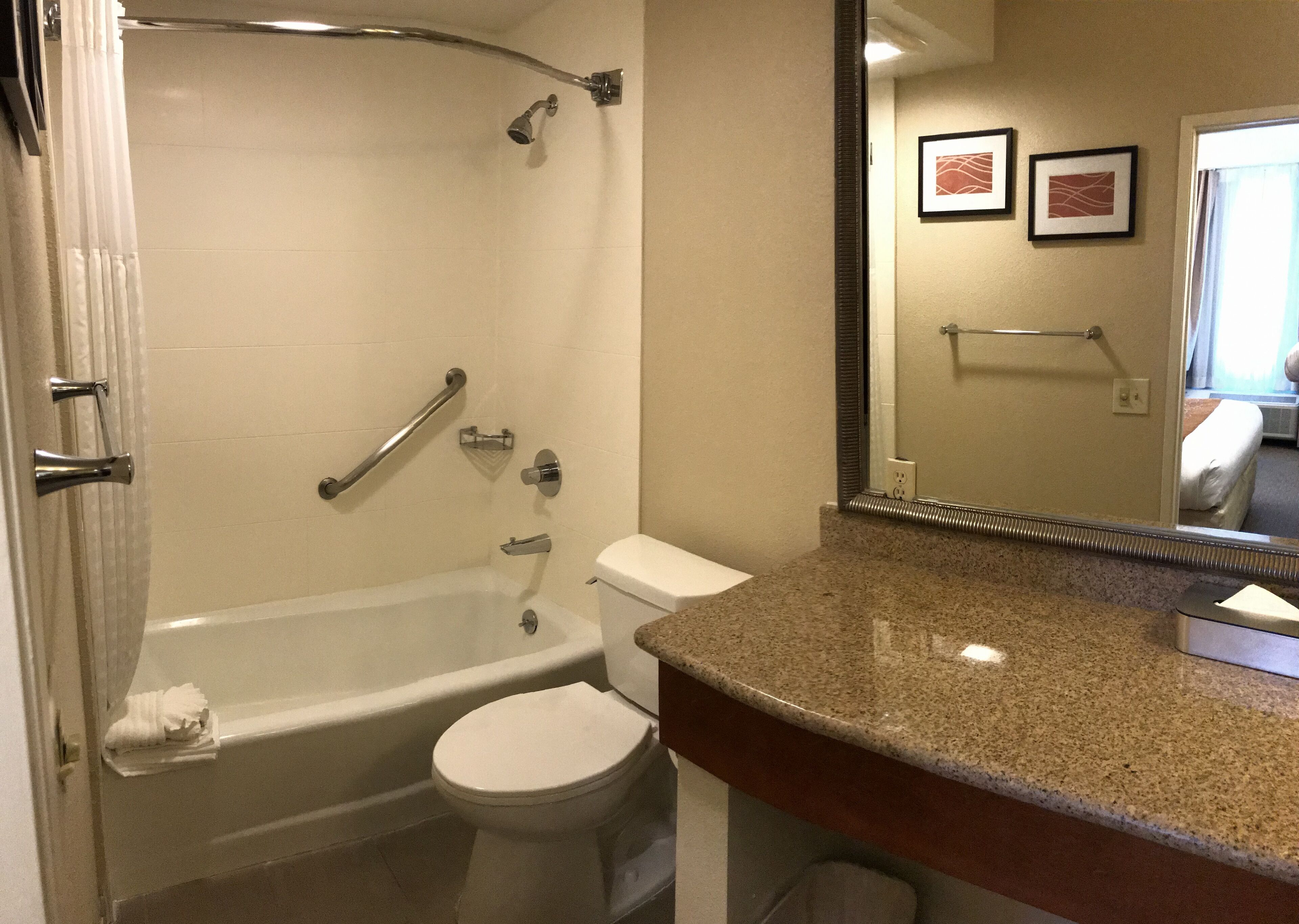 Une salle de bain avec une baignoire, des toilettes et un comptoir en granit.
