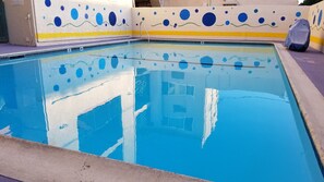 Una piscina al aire libre, tumbonas