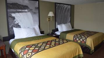 Habitación de hotel con dos camas, una mesita de noche, una lámpara y un cuadro grande de una cascada en la pared.