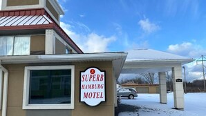 A motel sign, a covered parking area, and a snow-covered ground. - SuperB Hamburg Motel (Hamburg)