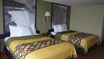 Een hotelkamer met twee bedden, elk voorzien van een beddekleed met dessin, een nachtkastje, een lamp en een groot schilderij van een waterval aan de muur.