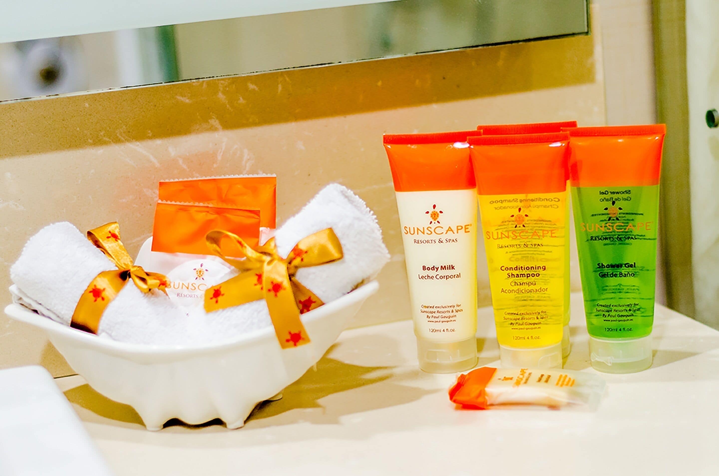 A bathroom with toiletries including body milk, conditioning shampoo, and shower gel.