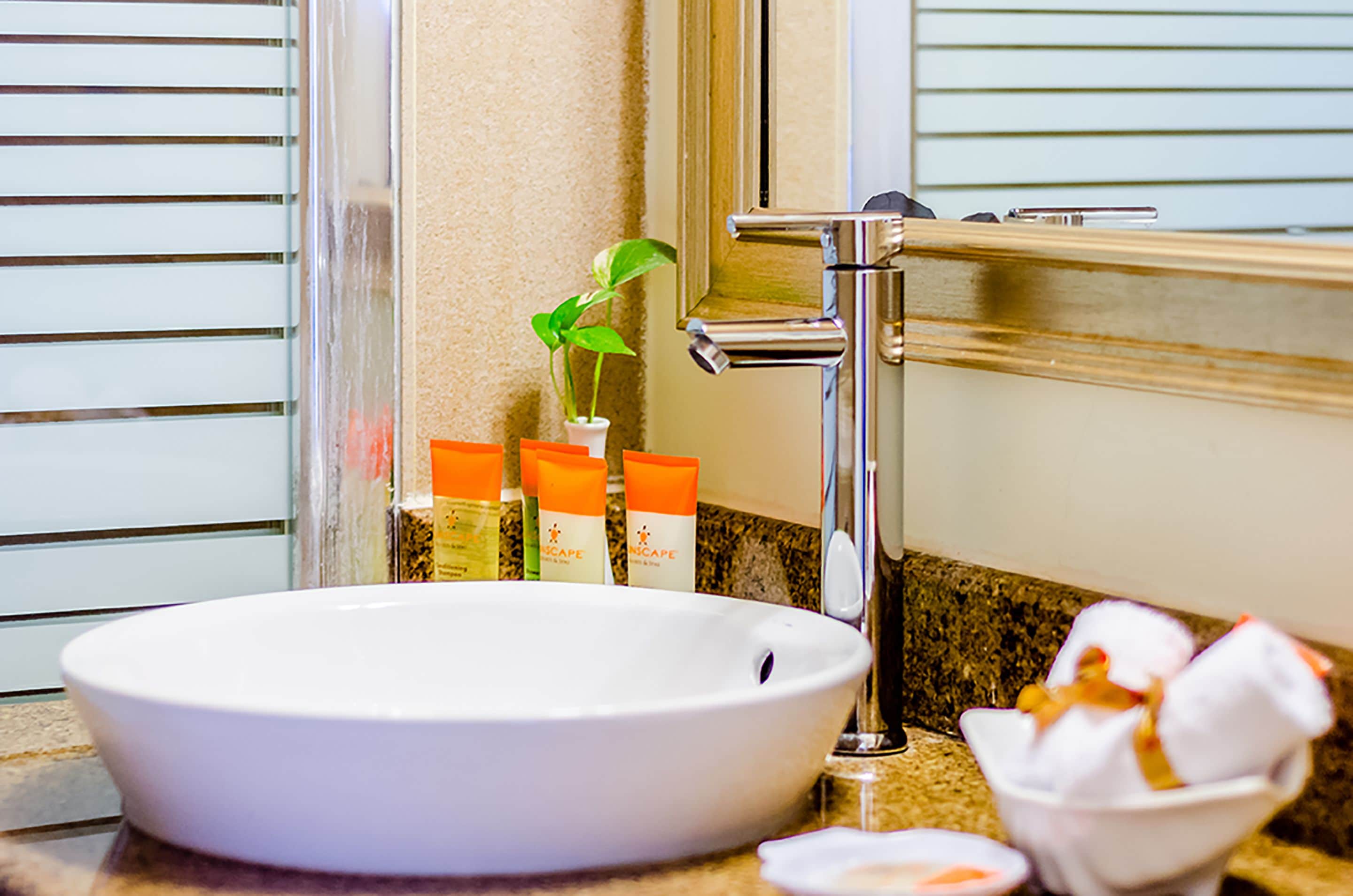 A bathroom sink with a white basin, a chrome faucet, and toiletries on the counter.