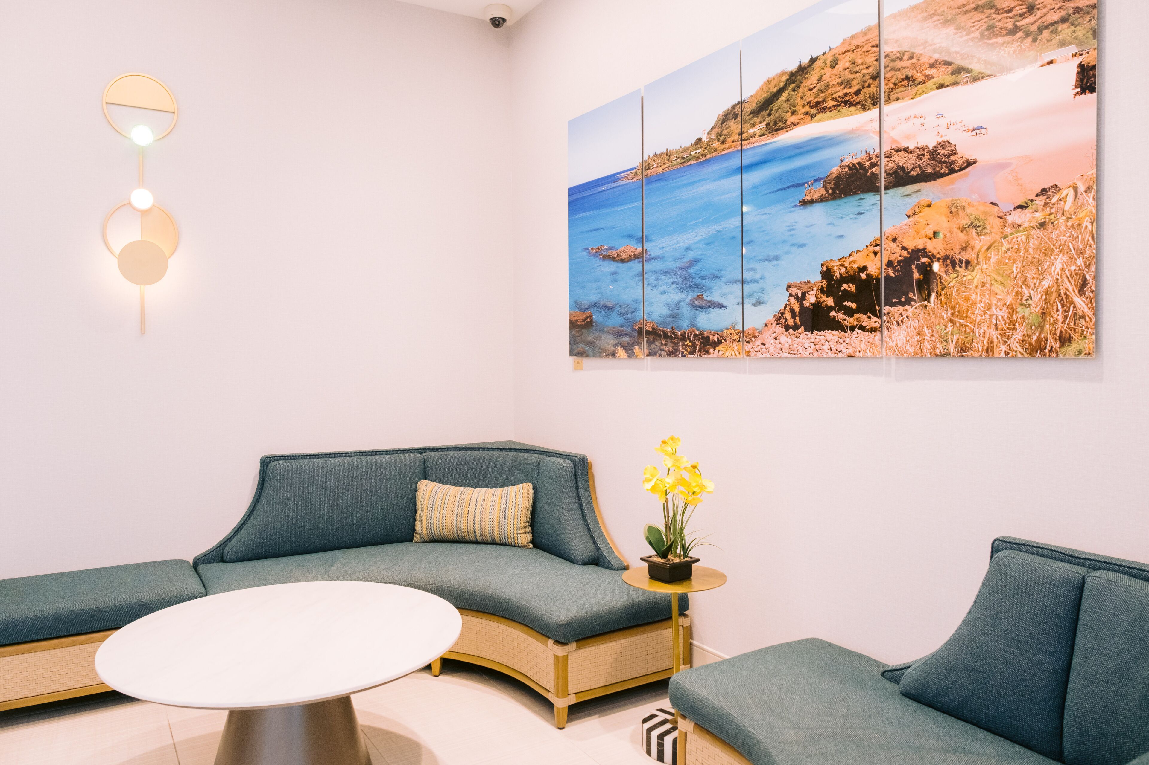 A modern living room with a sectional sofa, a round coffee table, and a wall-mounted light fixture.