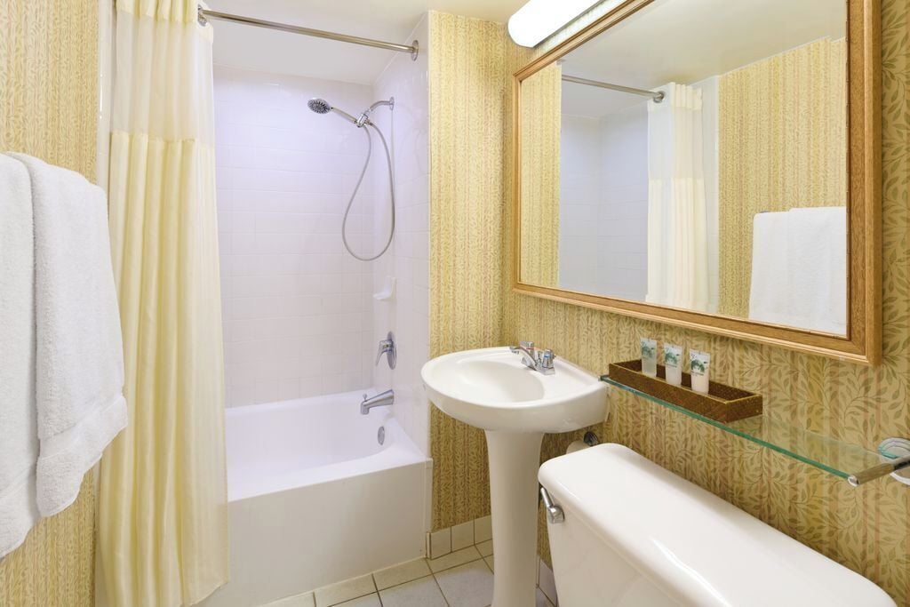A bathroom with a bathtub, a sink, and a mirror.