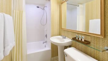 A bathroom with a bathtub, a sink, and a mirror.