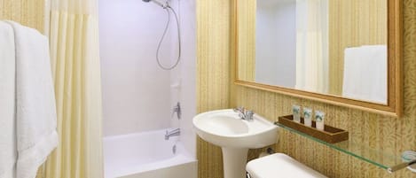 A bathroom with a bathtub, a sink, and a mirror.