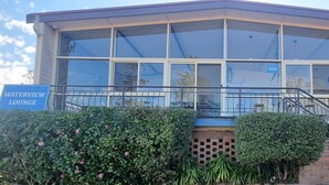 A building with large windows, a staircase, and signs for 'Waterview Lounge' and 'Guest Kitchen'. - Waterview Gosford Motor Inn (West Gosford)