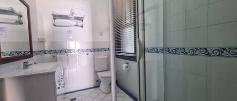 A bathroom with a toilet, sink, and towel rack.