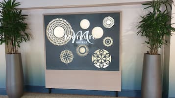 Una pared con un gran letrero de Mercure Hotels, rodeada de patrones circulares decorativos.