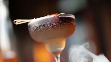A cocktail with a garnish, served in a glass with a stem.