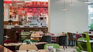 A restaurant interior with a bar area, multiple seating options, and pendant lighting.