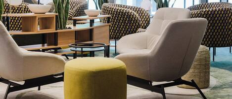 A modern living room with a sofa set, ottoman, and coffee table.