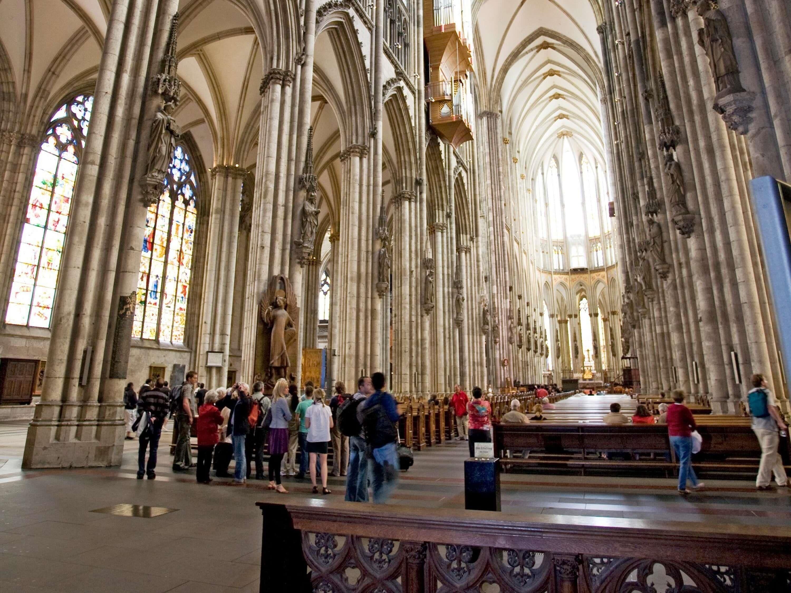 Ein Dominneres mit hohen Gewölbedecken, großen Buntglasfenstern und einem zentralen Altar.