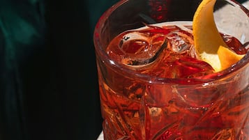 A glass with a textured pattern, ice cubes, and a citrus garnish.