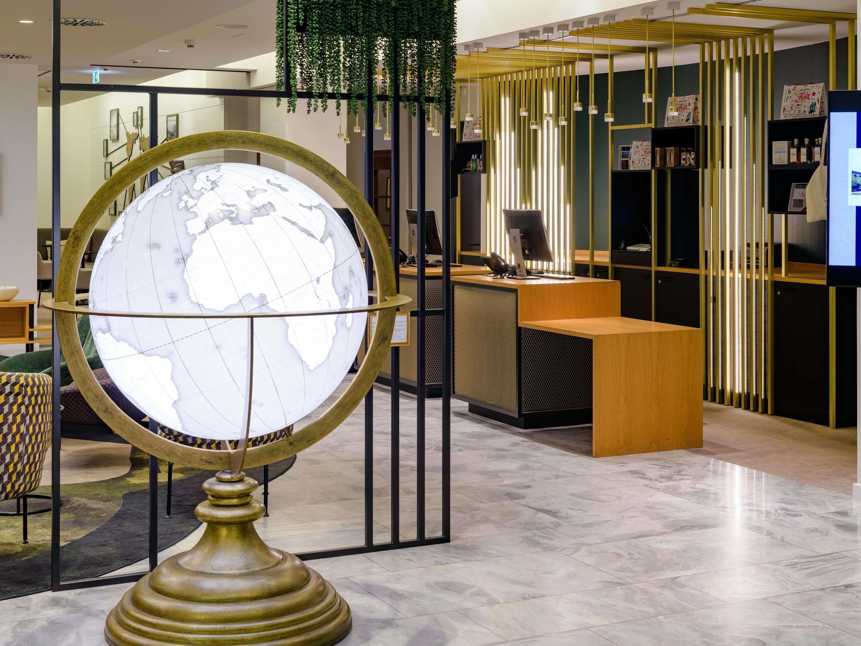 Et receptionsområde med en globus, et skrivebord og siddepladser.