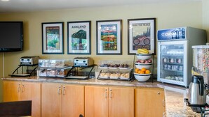 A kitchen with a countertop displaying various food items, a refrigerator, and a coffee machine.