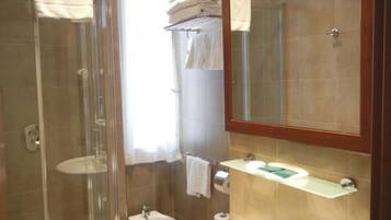 Ein Badezimmer mit Duschkabine, Waschbecken und Spiegel.