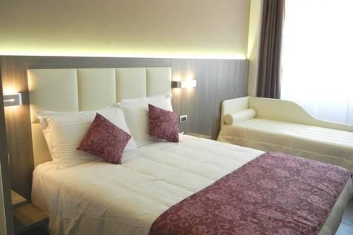 A hotel room with a large bed, two pillows, a bedside table, and a chair.