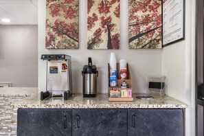 A kitchenette with a coffee machine, a water dispenser, and a coffee cup holder. - Red Roof Inn Greenville (Greenville)