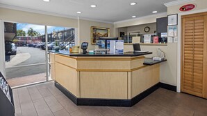 A reception area with a counter, a clock, and a sign for Disneyland Resort. - Del Sol Inn - Anaheim Resort (Anaheim)