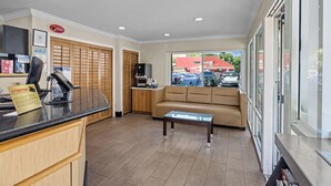 A reception area with a counter, a sofa, and a coffee station. - Del Sol Inn - Anaheim Resort (Anaheim)