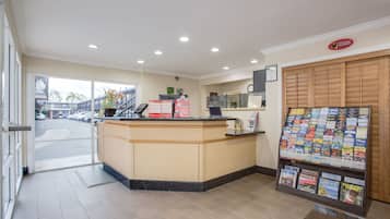 Un espace d’accueil comprenant un comptoir, un présentoir à magazines et donnant sur la rue.