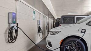 A white car charging at a JuiceBox station in a parking garage. - Del Sol Inn - Anaheim Resort (Anaheim)