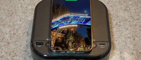 En telefon oplades i en dock med Disneys tema.