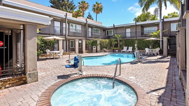 A hotel with a swimming pool, outdoor seating, and a hot tub. - Del Sol Inn - Anaheim Resort (Anaheim)