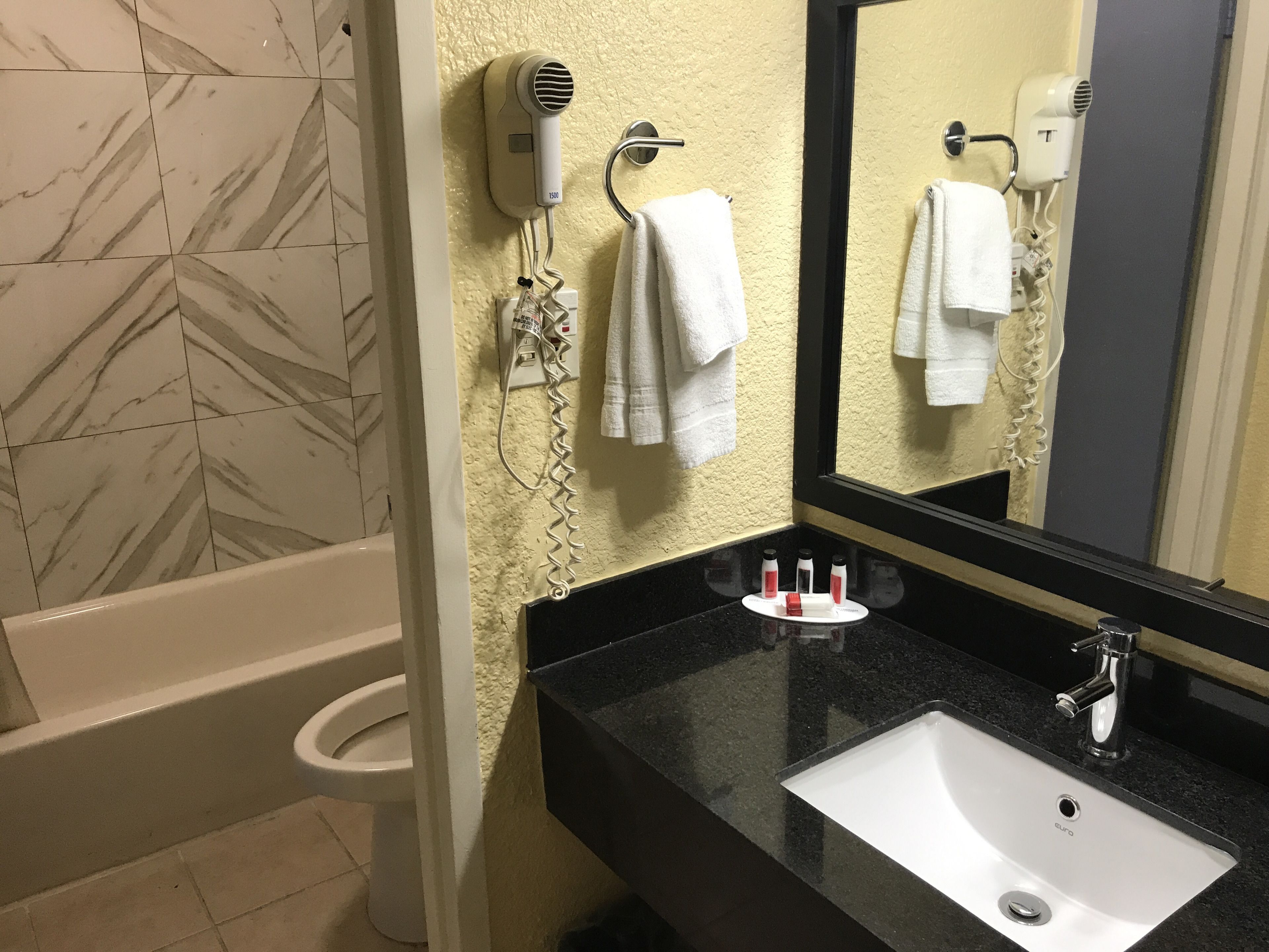A bathroom with a bathtub, a sink, and a mirror.