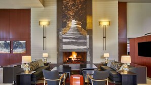A modern lobby with a fireplace, seating area, and artwork on the walls. - Hyatt Regency Lexington (Lexington)